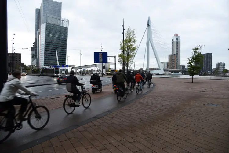 Pessoas andando de bicicleta em dia chuvoso e nublado