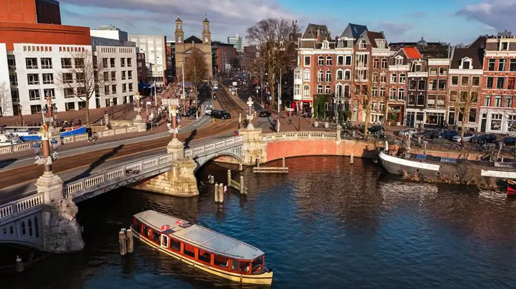 Canal de Amsterdam em dia de sol