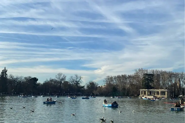Lado do parque El Retiro, em dia de sol com nuvens