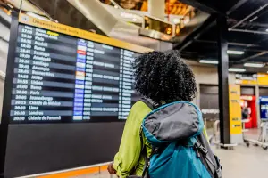 Mulher no aeroporto olhando para o time table