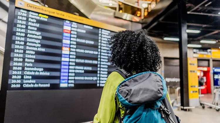 Mulher no aeroporto olhando para o time table