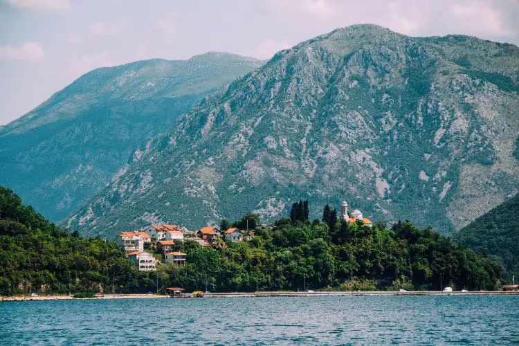 Pequenos vilarejos podem ser observados durante passeios de barco pela Baía de Kotor, junto com as montanhas que se erguem ao fundo