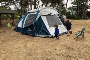 família montando uma barraca de camping.