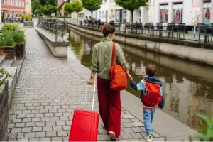 Mulher e criança caminhando com malas