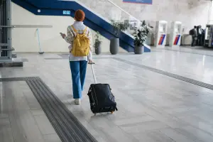 Jovem caminha com sua mala