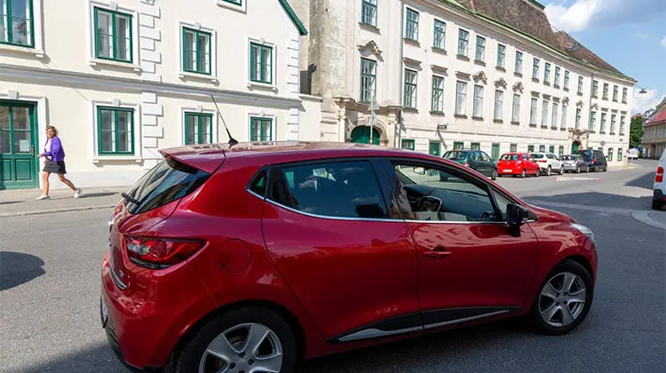 Carro vermelho em zona residencial, após o aluguel de carro em Viena