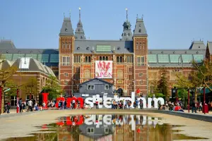 Placa I Amsterdam em frente a construção imponente
