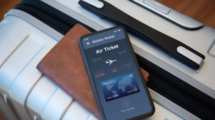 Celular e passaporte sobre mala