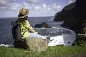 Mulher relaxa no alto de montanha na Europa, depois de contratar um seguro viagem da Assist Card