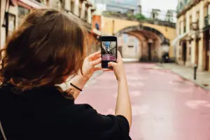Mulher tirando foto em ponto turístico em Portugal