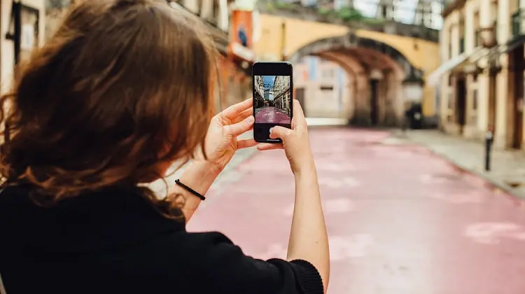 Mulher tirando foto em ponto turístico em Portugal