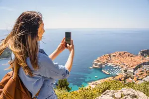 Turista tirando foto de paisagem marítima