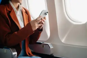 Mulher no avião usa celular com chip internet ilimitada internacional
