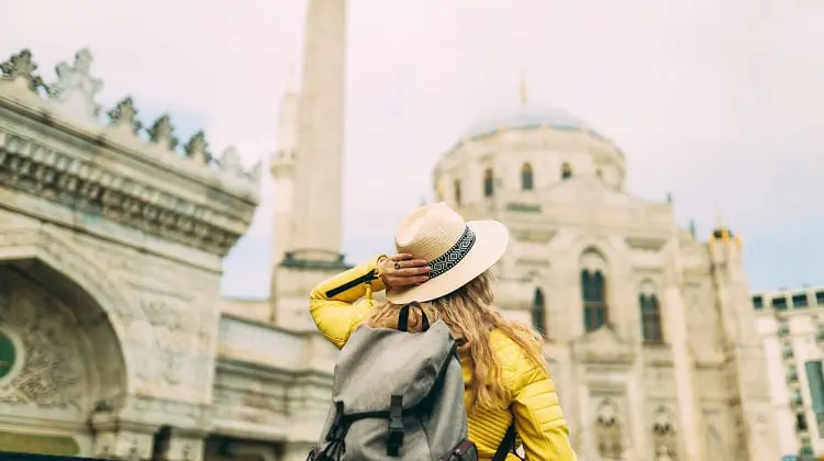 Mulher em viagem, fazendo passeio turístico. Você consegue comprar ingressos para a sua viagem no Civitatis.