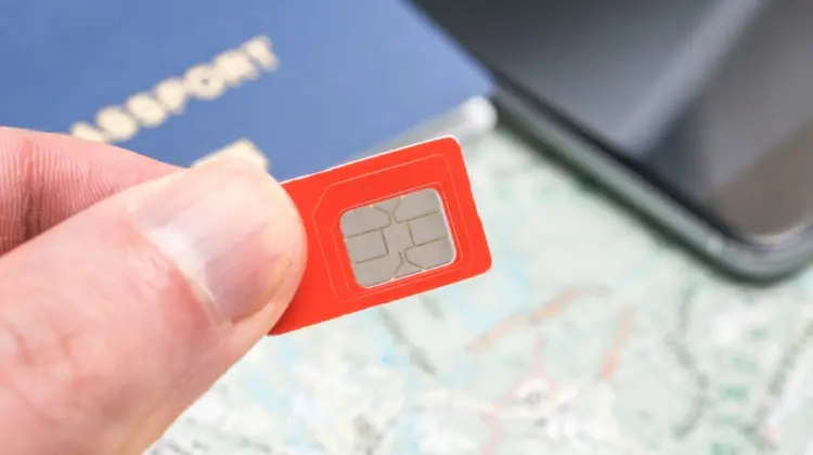 Turista segurando o seu chip internacional