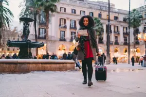 Turista chegando em Barcelona com malas e mapa