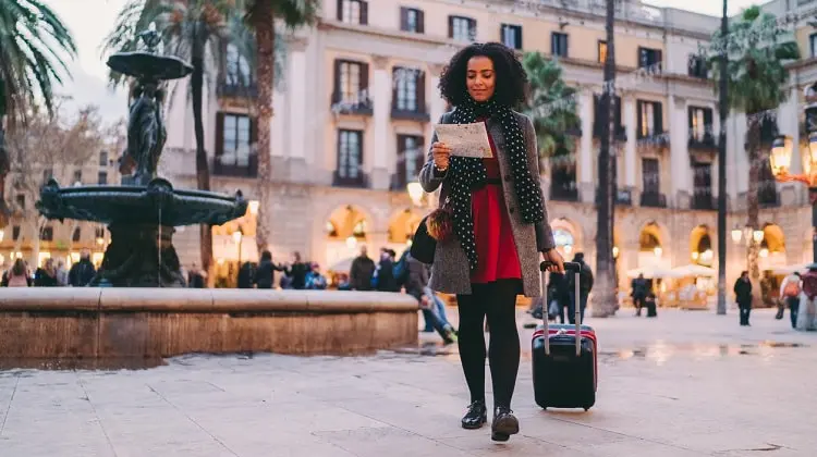 Turista chegando em Barcelona com malas e mapa