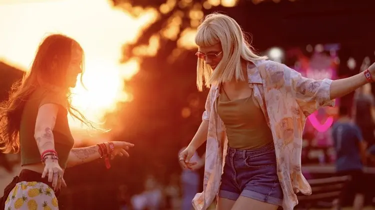 Amigas curtindo festival em pôr do sol na Europa.