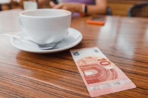 Mesa com café e nota de 10 euros