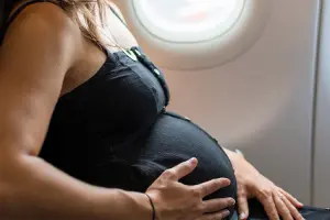mulher grávida sentada em poltrona de avião
