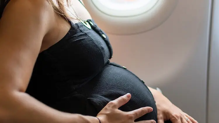 mulher grávida sentada em poltrona de avião