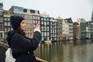 Mulher em Amsterdã com seguro viagem Europa da ITA