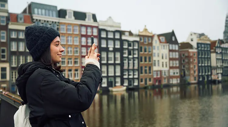 Mulher em Amsterdã com seguro viagem Europa da ITA