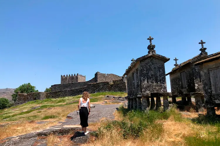 Vista do castelo de Lindoso e os espigueiros, mulher caminhando
