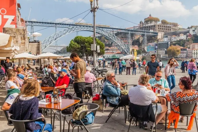 Pessoas sentadas em restaurantes no Porto, em Portugal