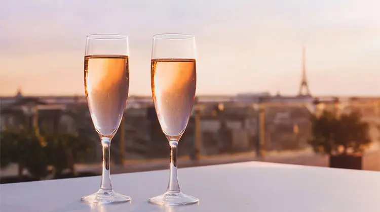 Taças de champagne com a Torre Eiffel ao fundo, em um dos melhores destinos para lua de mel na Europa