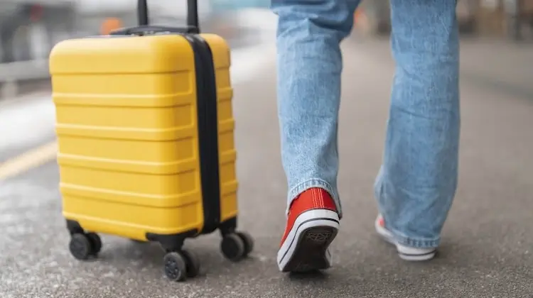 Pessoa no aeroporto puxando uma mala Lansay para viagem