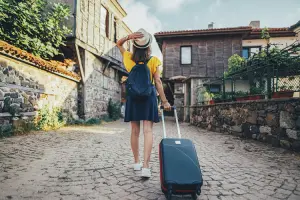 Turista passeando com mala de rodinhas que poderia ser uma mala Santino.