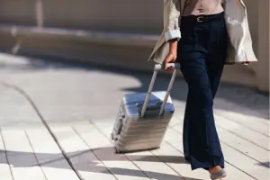 Mulher caminha segurando mala