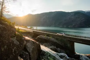 Paisagem de uma cidade da Europa, com um carro na estrada, no pôr do sol