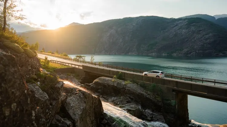 Paisagem de uma cidade da Europa, com um carro na estrada, no pôr do sol