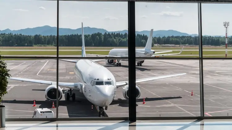 Avião na pista do aeroporto sendo visto da sala de embarque.