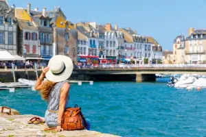 Turista sentada em trapiche olhando o mar