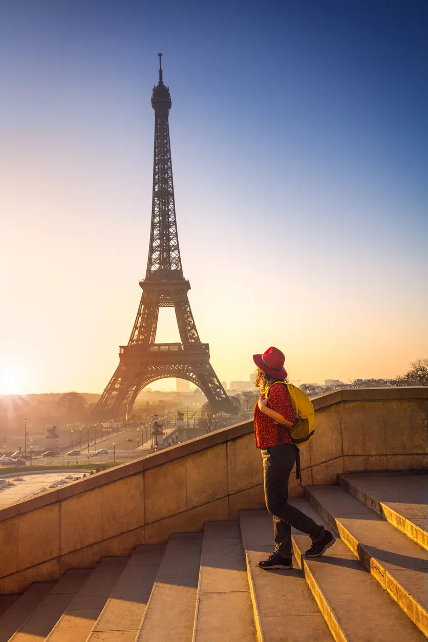 Mulher caminhando próximo a Torre Eiffel