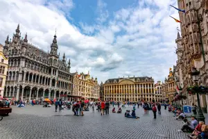 Turistas visitam a Grand Place, em Bruxelas, em tarde de céu azul