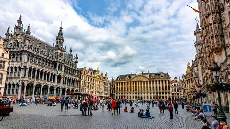 Turistas visitam a Grand Place, em Bruxelas, em tarde de céu azul