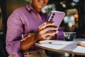 Mulher usando celular com mysimtravel inserido.
