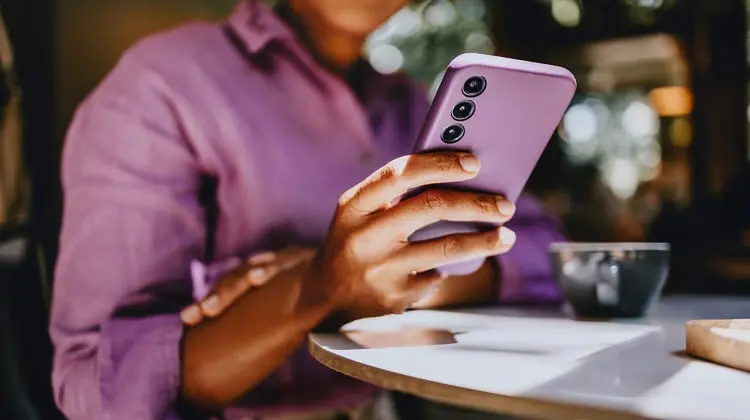 Mulher usando celular com mysimtravel inserido.