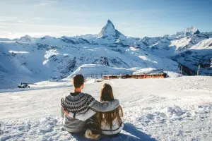 Casal admirando montanha famosa coberta de neve nos alpes suíços.