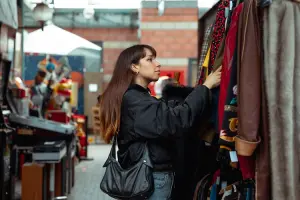 Mulher decidindo o que comprar em Paris, em brechó de rua.