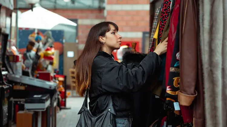Mulher decidindo o que comprar em Paris, em brechó de rua.