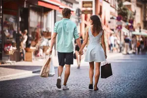 Casal caminha na rua com sacolas de compras na Alemanha