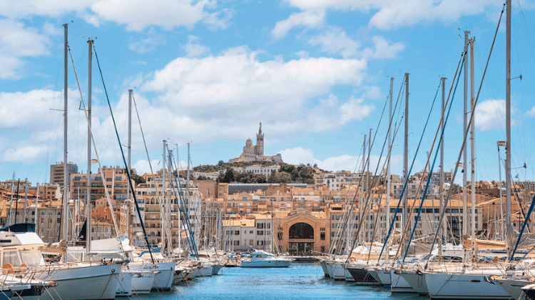 O Vieux-Port de Marselha, com seus barcos ancorados e a imponente Basílica de Notre-Dame de la Garde ao fundo