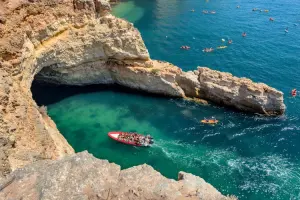 Vista aérea de barco entrando na Gruta de Benagil, no Algarve, em Portugal.