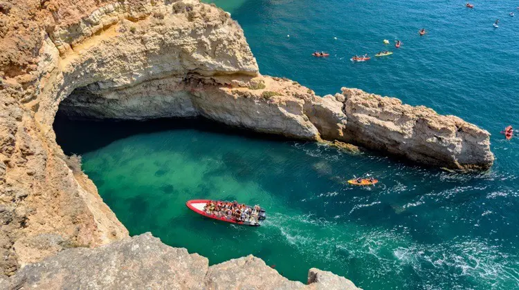 Vista aérea de barco entrando na Gruta de Benagil, no Algarve, em Portugal.