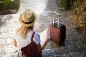Viajante sentada repassando o que não pode esquecer numa viagem a Europa